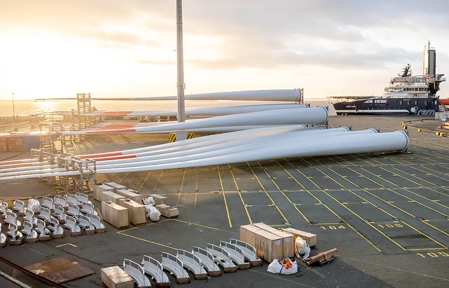 Junge Mitarbeiterinnen und Mitarbeiter der BLG posieren neben zwei Gabelstaplern (Foto)
