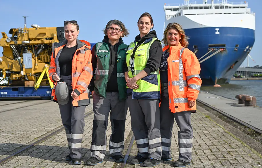 Four women in work clothes at the harbor (Photo)