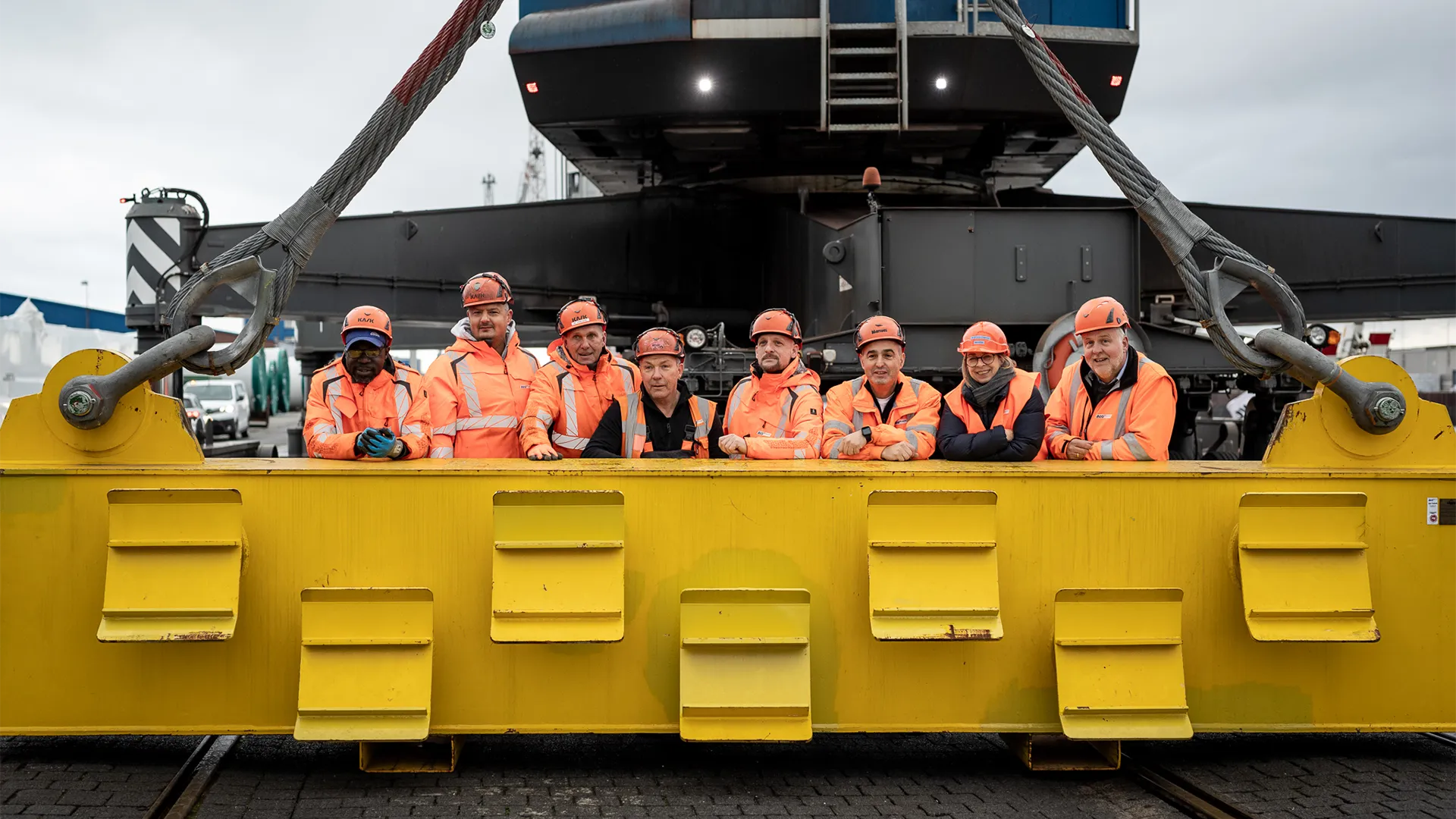 Eine Gruppe von BLG Mitarbeitenden steht in Sicherheitsbekleidung an einer großen Maschine