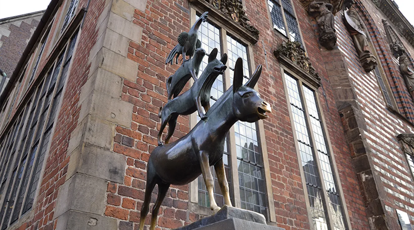 Bremer Stadtmusikanten als Statue vor Backsteinfassade (Foto)