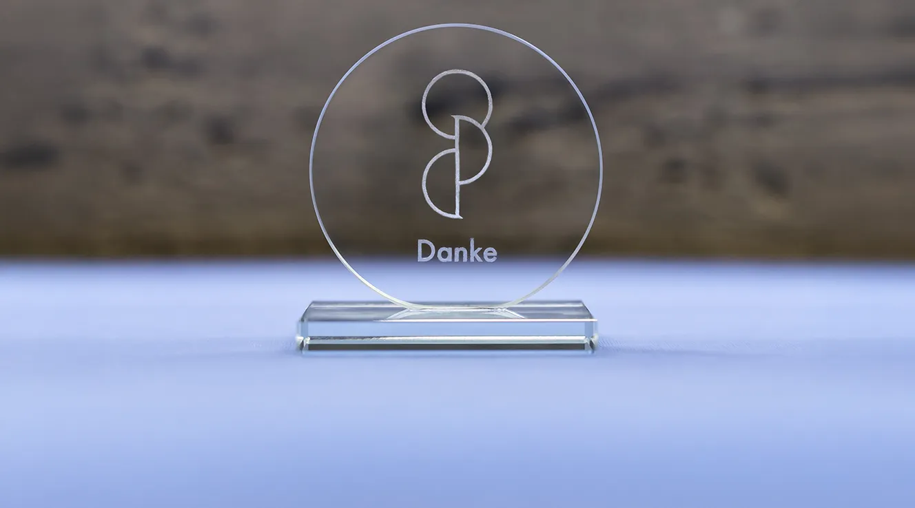 Trophy with “Danke” inscription on a blue table (Photo)